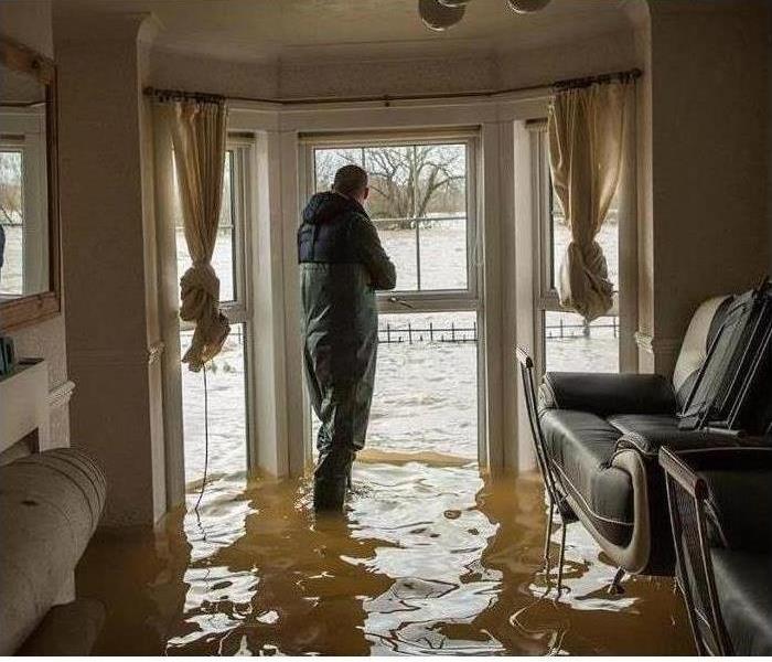 Man standing in a home with water damage
