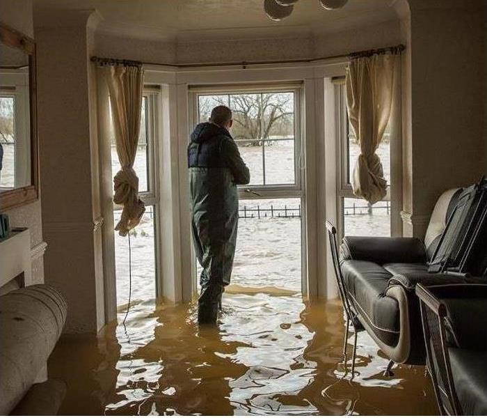 SERVPRO Estimator inspecting damage in flooded home. 